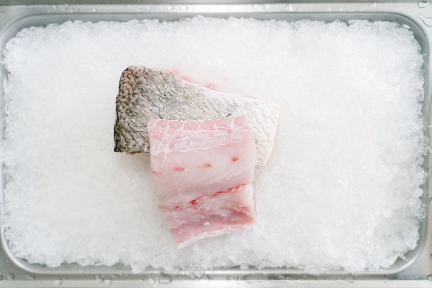 Fresh white fish fillets displayed on crushed ice
