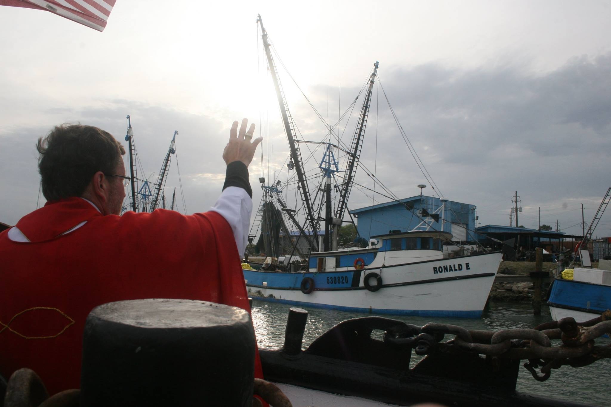 A Catholic priest blessing the RONALD E at the docks